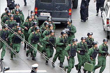 AFP - Chinese police SWAT team members take position around a primary school in Shanghai, 24 February 2005 after a man held a student hostage in a classroom. China has been