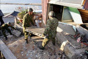 r_Japanese soldiers remove debris from houses destroyed by an earthquake