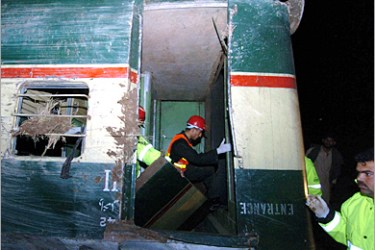 AFP - Pakistani rescue workers search inside a coach of a derailed passenger train in Babakwal, some 25 kilometers east of Lahore, 05 March 2005. At least five passengers were killed