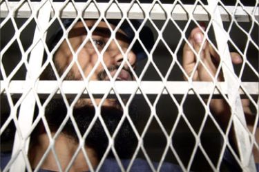 On of Al-Qaeda suspects looks from behind the court bars during his final trial hearing at Sanaa's special court 09 March 2005.