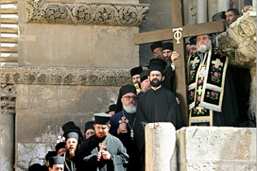 AFP - Greek Orthodox priests pray outside the Church of the Holy Sepulcher in Jerusalem's Old City, 29 April 2005, during the Good Friday procession. Thousands of Orthodox pilgrims