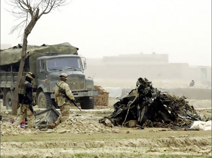 Two US soldiers walk nearby the wreckage of a US CH-47 Chinook helicopter in Ghazni province some 100 kms (60miles) south east of Kabul, 07 April 2005. Sixteen people have been confirmed dead and two are missing after a US military helicopter crashed in south eastern Afghanistan Wednesday, the US military said, updating the death toll from nine. AFP PHOTO/ SHAH Marai