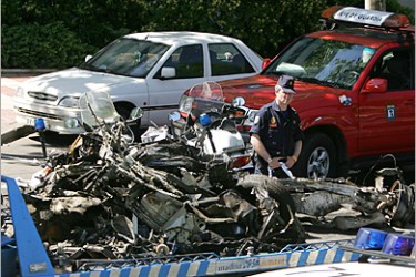AFP - The car in which a bomb exploded is towed by police early 25 May 2005 in the Spanish capital Madrid. A powerful car bomb slightly injured three people in the Spanish capital