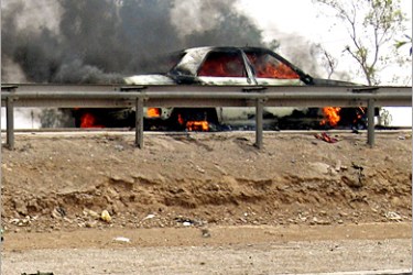 AFP - A car is gutted by fire following a car bomb against an Iraqi police convoy in the Dora district of south Baghdad, 25 May 2005. One man was killed and eight Iraqi police commandos were wounded when a car detonated as their convoy drove