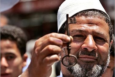 REUTERS/ A Palestinian refugee displays a key during a demonstration marking the 57th anniversary of Nakba (Day of catastrophe) in Gaza City May 15, 2005. Israel is celebrating the 57th