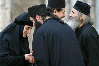 f_A Greek Orthodox nun and three priests meet 30 May 2005 near the church of the