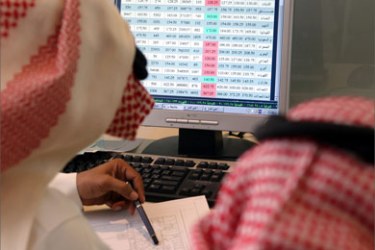 Two Saudis follow the stock market's movement on a computer screen at the Saudi-British Bank in Riyadh 06 June 2005.