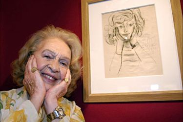 f_Genevieve Laporte, 79-years-old, poses next to her portrait painted by Spanish
