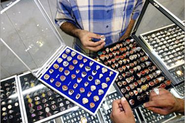 AFP - A man tries on a ring at a jewelry store in central Baghdad 21 August 2005. Iraqi Muslim men, wear as many as four rings on their hands, mainly silvers inlayed with a semi-precious