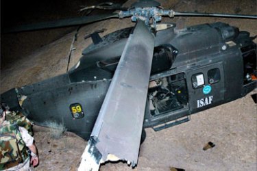 Soldiers of the International Security Assistance Force (ISAF) inspect a second Spanish ISAF helicopter damaged in western Afghanistan near the city of Herat