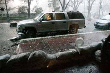 AFP - A street lamp cover rolls down the sidewalk outside the Best Western hotel at St. Charles and Poydras avenues in downtown New Orleans, Louisiana as Hurricane Katrina