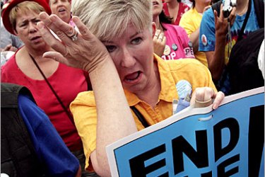 AFP / Dorothy Goldie of St. Paul, Minnesota, listens to Cindy Sheehan's address to thousands gathered near the White House before a march against the Iraq War