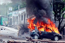 AFP / People from the Cormoros Island look on while the Minister of the Public Function Ms. Sity Maoulida's car burns at a barricade in a street in Moroni, Comoros, 24 September