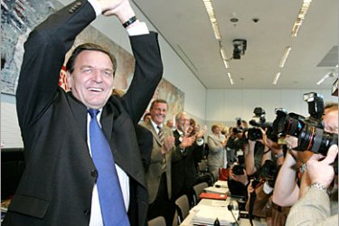 AFP / German Chancellor Gerhard Schroeder cheers as he arrives for a meeting with his parliamentary group at the parliament in Berlin 20 September 2005. After Germany's general