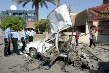 Iraqi policemen secure the site where a car bomb exploded in central Baghdad, 05 October 2005. Iraq was under fire over changes to the electoral law that make it harder for voters to reject the war-wracked country's new but deeply divisive constitution in a referendum next week.