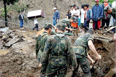 AFP Local residents and relatives of the victims look at soldiers digging out people buried in a landslide 03 October, 2005 in Lourdes Colon, Libertad department, 20 km from San