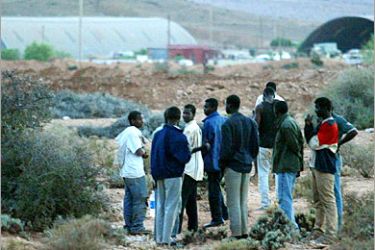 f - African immigrants appear ouside a detention camp near Guelmim, waiting for transfer and expulsion to their country 13 October 2005. They were among thousands