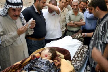 Iraqis cry over the body of a two-year-old girl who was killed 06 October 2005 with her father, a retired Iraqi police, in a drive-by-shooting in the city of Kirkuk, north of Baghdad.