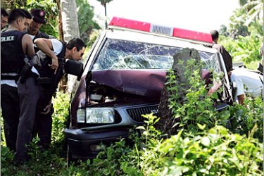 REUTERS/ Police officers inspect a bullet-riddled police vehicle in Pakalusong village, southern Thailand's Pattani province, October 4, 2005. Shootings, especially of Buddhist teachers