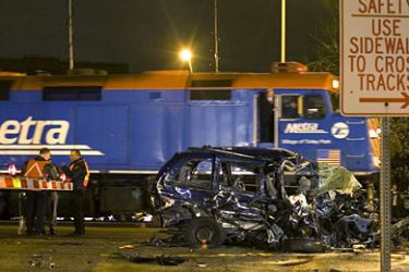 epa00581479 A Metra locomotive passes demolished autos that litter the railroad crossing after a Metra commuter train crash during the holiday rush hour in Elmwood Park, Ill, in suburban Chicago, on Wednesday, 23 November, 2005. A commuter train collided with five cars, which reportedly triggered a chain reaction involving more than 13 vehicles. EPA/STEPHEN J. CARRERA