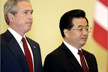 AFP CORRECTION - US President George W. Bush (L) attends a welcoming ceremony with Chinese President Hu Jintao at the Diaoyutai State Guest House in Beijing, 20 November