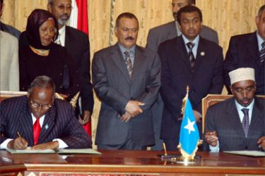 Yemeni President Ali Abdullah Saleh (C) looks on as Somali President Abdullahi Yusuf (L) and Parliament Speaker Sharif Hassan Sheikh Adan (R) sign a Yemeni-sponsored declaration in the southern Yemeni port city of Aden January 5, 2006.