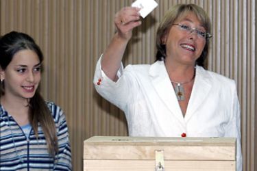 f_Chile's presidential candidate for the center-left coalition Michelle Bachelet shows her vote next to her