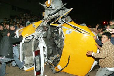 r_Palestinians inspect a car damaged after an Israeli missile strike in northern Gaza Strip January 2, 2006