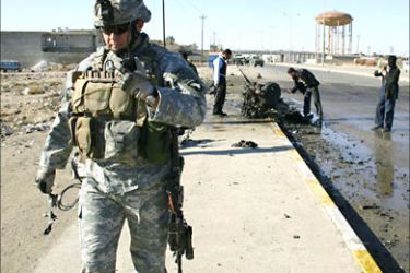 f_A US soldier walks away from the scene of a car bomb in the northern oil-rich city of Kirkuk 01 January