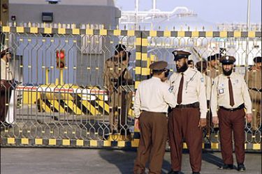 f_Saudi security men stand at the entrance of the oil processing plant of the state oil giant