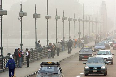 f_Vehicles drive on a bridge over the Nile River while fog and dust cover most of Cairo and the north Delta of Egypt 25 February 2006. The dust was blown across the Mediterranean Sea by strong winds from Africa. AFP PHOTO/KHALED DESOUKI