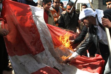 Palestinian students burn a Danish flag in the West Bank city of Hebron 20 February 2006, during a demonstration to protest against cartoons of the Prophet Mohammed published in Europe some weeks ago. AFP