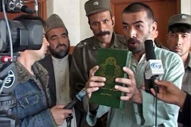 A TV frame grab, aired on March 22, 2006, shows Abdul Rahman holding a translated version of the Bible at a Kabul court. Under mounting international pressure over the case of a man facing the death penalty for converting to Christianity,