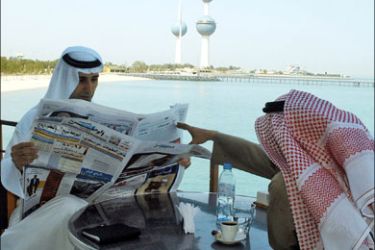 afp - Kuwaitis read a local newspaper at restaurant in Kuwait City 06 March 2006. Kuwait's parliament today passed a new press law banning the imprisonment of journalists