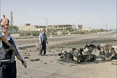 f_An Iraqi police secures the site where a suicide bomber, driving a car, blew himself up near a