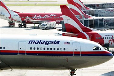 -REUTERS /A Malaysian Airlines aircraft is parked next to an AirAsia jet at Kuala Lumpur International Airport in Sepang, outside Kuala Lumpur, in this February 27, 2006 file photo. Malaysia's