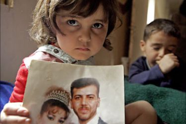 f_Farah a nine-year old Palestinian girl, shows the wedding picture of her father Adnan Abdullah at her apartment at Baghdad's eastern Baladiat district, 26