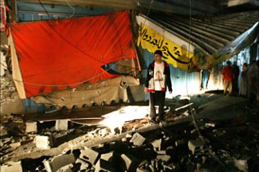 f_A Palestinian youth inspects a damaged Fatah movement office after it was targeted by an Israeli air