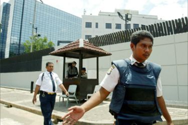Embassy security personnel stand guard in front of the Australian embassy in Jakarta April 2, 2006. Indonesia tightened security in key places after the U.S. and Australian warned of possible attacks against Westerns in the country on Sunday, police said.