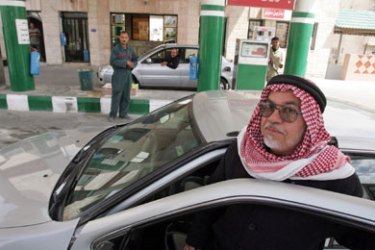 A Jordanian gets into his car after filling it with gasoline at a petrol station in Amman April 9, 2006. Police arrested more than 100 Islamist activists for distributing posters