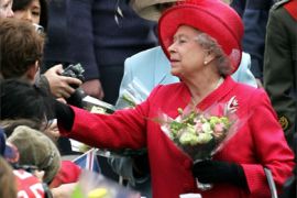 Britain's Queen Elizabeth II (R) receives flowers and gifts from well-wishers as she walks along Windsor High Street in Windsor as part of her 80th Birthday celebrations, 21 April 2006