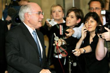 f_Australian Prime Minister John Howard (L) walks past waiting media as he leaves after being questioned