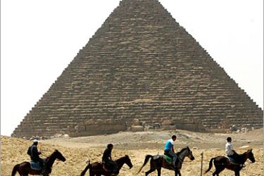 Tourists ride horses in front of Giza pyramids on April 23, 2006. REUTERS/Goran Tomasevic