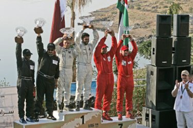 epa00724321 Qatari driver Nasser Salleh al Attiya and co-driver Chris Paterson (white suits) celebrate their victory at the Jordan Rally with the Dead Sea in the backgorund,