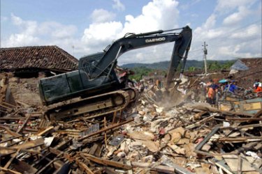 Indonesian soldiers use a digger to clear rubbles from a collapsed market in Bantul, Central Java's Yogyakarta province, 28 May 2006, a day after a an earthquake shattered the area.