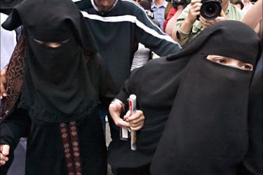 f_Veiled women escorted by other family members of the accused in a Toronto terrorism plot make their way through a throng of media as they leave the courthouse in the Toronto suburb of Brampton as the suspects appeared in court 06 June 2006.