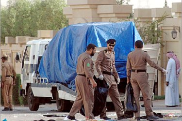 .REUTERS/ Police officers are seen removing several vehicles damaged in a clash with suspected al Qaeda-linked militants in Riyadh June 23, 2006. Six suspected al Qaeda-linked militants and a policeman were killed in a shootout in the Saudi capital