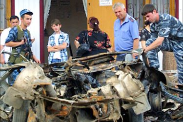 f_Chechen police investigators work at the site of exploded car in front of a cafe in central Grozny, 27 June 2006