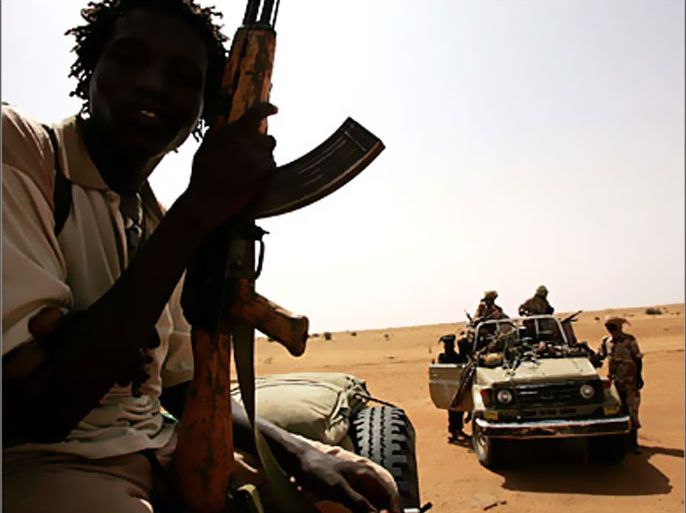 REUTERS/ Men belonging to the Sudanese Liberation Army fighters from the faction of Minni Minawi who signed the Darfur Peace agreement sit on a vehicle during UNICEF Good Will Ambassador Mia Farrow's visit at Galap camp north of