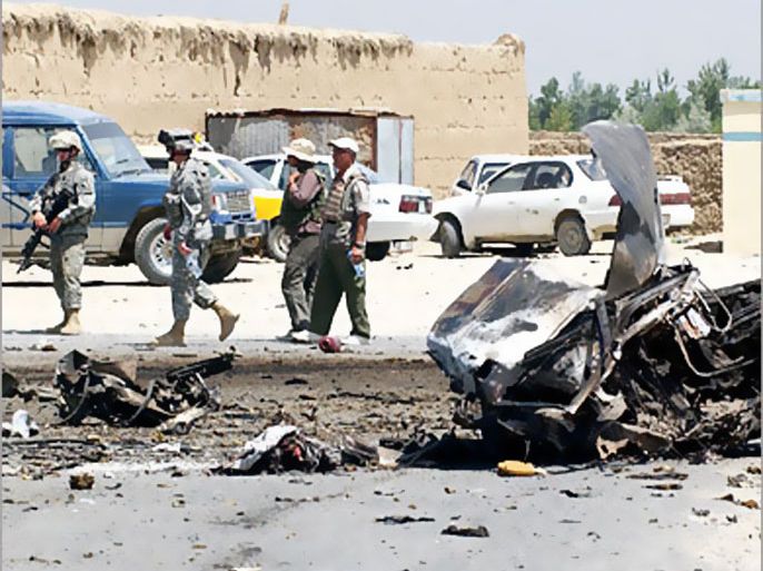 AFP - US soldiers stand guard at the site of a suicide attack near the main US base in Afghanistan at Bagram, some 50 kms north of Kabul, 26 June 2006. A suicide car bomber blew himself up near a convoy at the biggest US base in